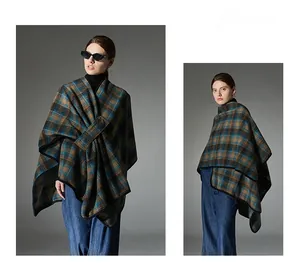 Detail of plaid poncho wrap with buckle closure and premium contrast piping finish