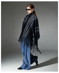 Full-length view of dark blue knit shawl with white geometric patterns and long fringes