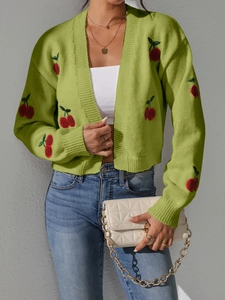 Detail of green knitted cardigan with red cherry embroidery and ribbed cuffs