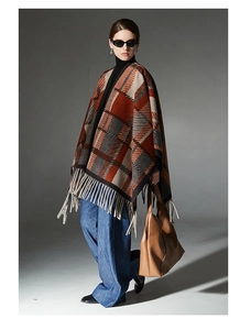 Detailed close-up of camel plaid shawl fringe and thick wool-like woven texture
