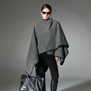 Chic black and white striped knit poncho for women with elegant buckle and drape