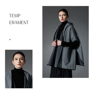 Detail of grey herringbone hooded cape featuring black contrast trim and elegant texture