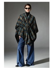 Detail of navy blue and brown plaid poncho showing asymmetrical layering and soft texture