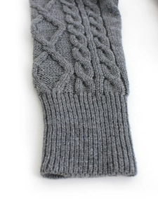 Detailed close-up of dark grey cable knit sweater cuff with ribbed edge design