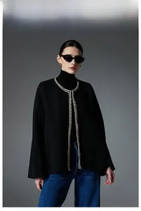 Detail view of black tweed shawl with gold braided trim and elegant luxury texture