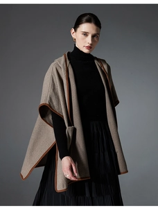 Detailed herringbone wool blend texture with elegant contrast trim on khaki cape