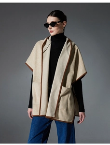 Detail of hooded plaid poncho with side pockets and premium brown trimmed edges