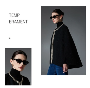 Detail of tweed cape coat with woven silver trim and textured black bouclé fabric finish