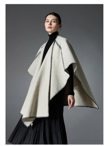 Detail of grey woolen shawl with black blanket stitching edge on a female fashion model