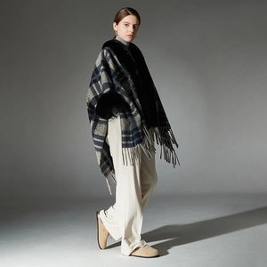 Women's plaid poncho coat with black faux fur collar and tassel trim in navy blue