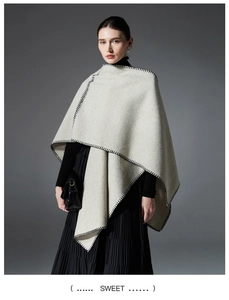 Close-up of light gray wool cape featuring decorative black whipstitch edge detailing