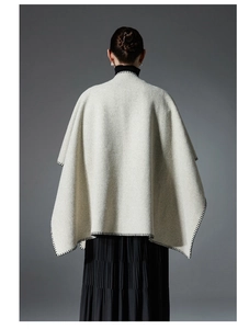 Detailed back view of oatmeal wool shawl featuring black contrast stitching and elegant drape