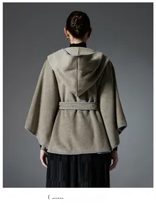 Detail of khaki hooded poncho cape showing thick wool texture and grey edge binding