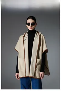 Detail of hooded plaid poncho featuring large front pockets and contrast brown trim detail