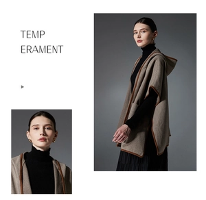 Detail of the elegant oatmeal herringbone hooded poncho featuring dark brown bound edges