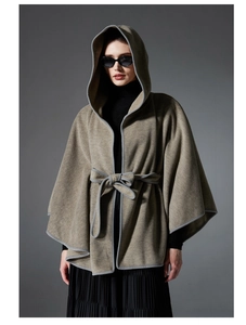 Detail of hooded wool poncho with contrast grey piping and matching waist belt