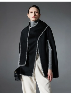 Detailed blanket stitch on a black wool cape shawl for a stylish winter layered look