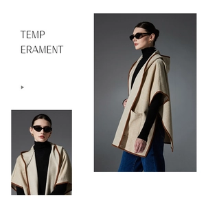 Detail of beige plaid hooded poncho showing brown edge piping and hidden side pockets