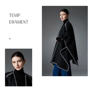 Detail of black wool cape coat showing white contrast stitching and minimalist design