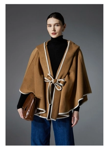 Detail of camel hooded cloak with white piping and waist tie bow closure