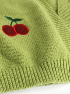 Close-up of grass green knit cardigan with delicate cherry embroidery and ribbed hem