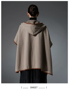 Detail of herringbone wool poncho cape with hood and contrast brown edge binding