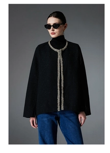 Detail of black tweed cardigan with silver woven trim and classic elegant texture