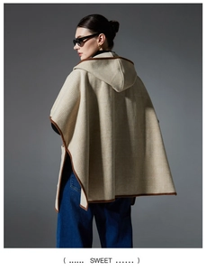 Detail of checkered hooded poncho featuring contrast brown piping and wool-like texture