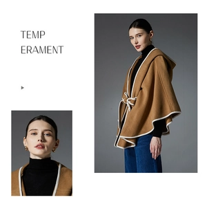 Detail view of camel hooded wool cape featuring white contrast piping and waist tie belt
