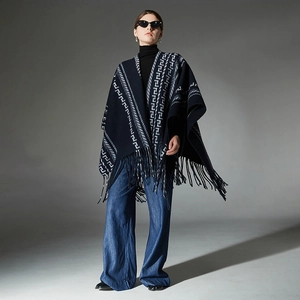Dark blue knit poncho with white geometric patterns and long tassels for autumn