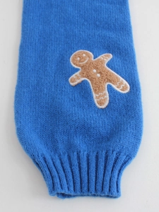 Detail of royal blue knit sweater with gingerbread man embroidery and ribbed cuff