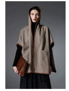 Detail of herringbone pattern fabric on a hooded poncho with dark brown trim detail
