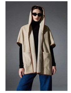 Detail of hooded plaid poncho with front pockets and contrasting edge binding