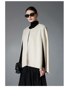 Detail view of cream wool blend cape coat with side slits and smooth premium texture