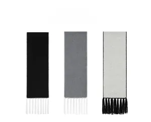 Dettaglio delle frange della sciarpa in nero, grigio scuro e grigio chiaro in lana