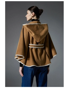 Detailed view of camel hooded poncho coat featuring white contrast trim and waist belt