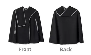 Detail view of black poncho featuring contrasting white stitching on front and back