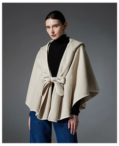 Detail of the elegant bow tie closure and premium wool-like texture on beige hooded poncho
