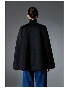 Back view of a minimalist high-neck black wool blend poncho cape with structured silhouette