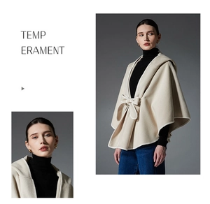 Detail of a beige hooded cape featuring an elegant bow tie closure and premium hemmed edges