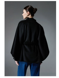 Detail view of the black wool shawl coat featuring a waist belt and elegant silhouette