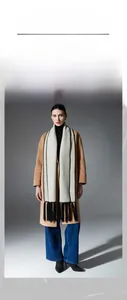 Detail of double-sided woolen tassel scarf featuring contrast stitching and soft fringe