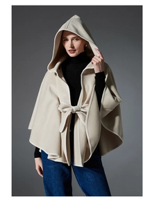 Detail view of beige hooded cape with soft wool texture and elegant bow-tie closure