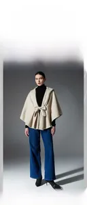 Detail of elegant beige hooded shawl cape with front bow tie closure for winter wear