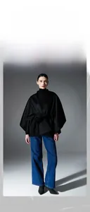 Détail du tissu en laine double face texturé d'un châle noir avec ceinture