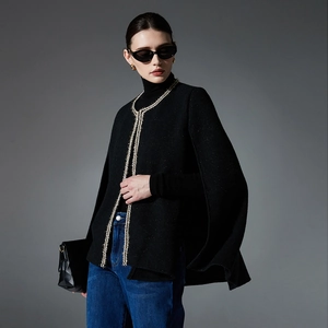 Women's black tweed cape jacket with gold metallic trim and vintage Chanel style