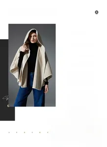Detail of elegant beige hooded poncho cloak paired with a casual outfit and minimalist style