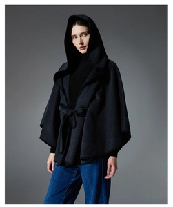 Detail of dark grey hooded cape featuring thick wool texture and waist tie belt