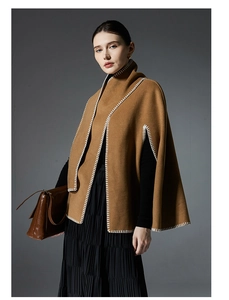 Detail of camel wool poncho shawl with white contrast stitching and wool texture