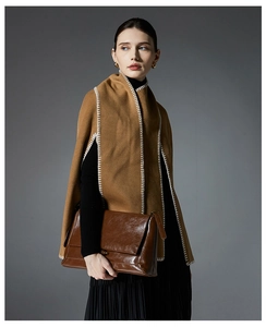 Detail of camel wool poncho with prominent white contrast stitching on the shoulder